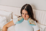 lady with cream medallion microwavable neck wrap on neck and shoulders