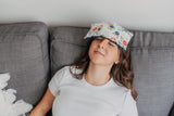 lady with navy floral eye pillow on her forehead
