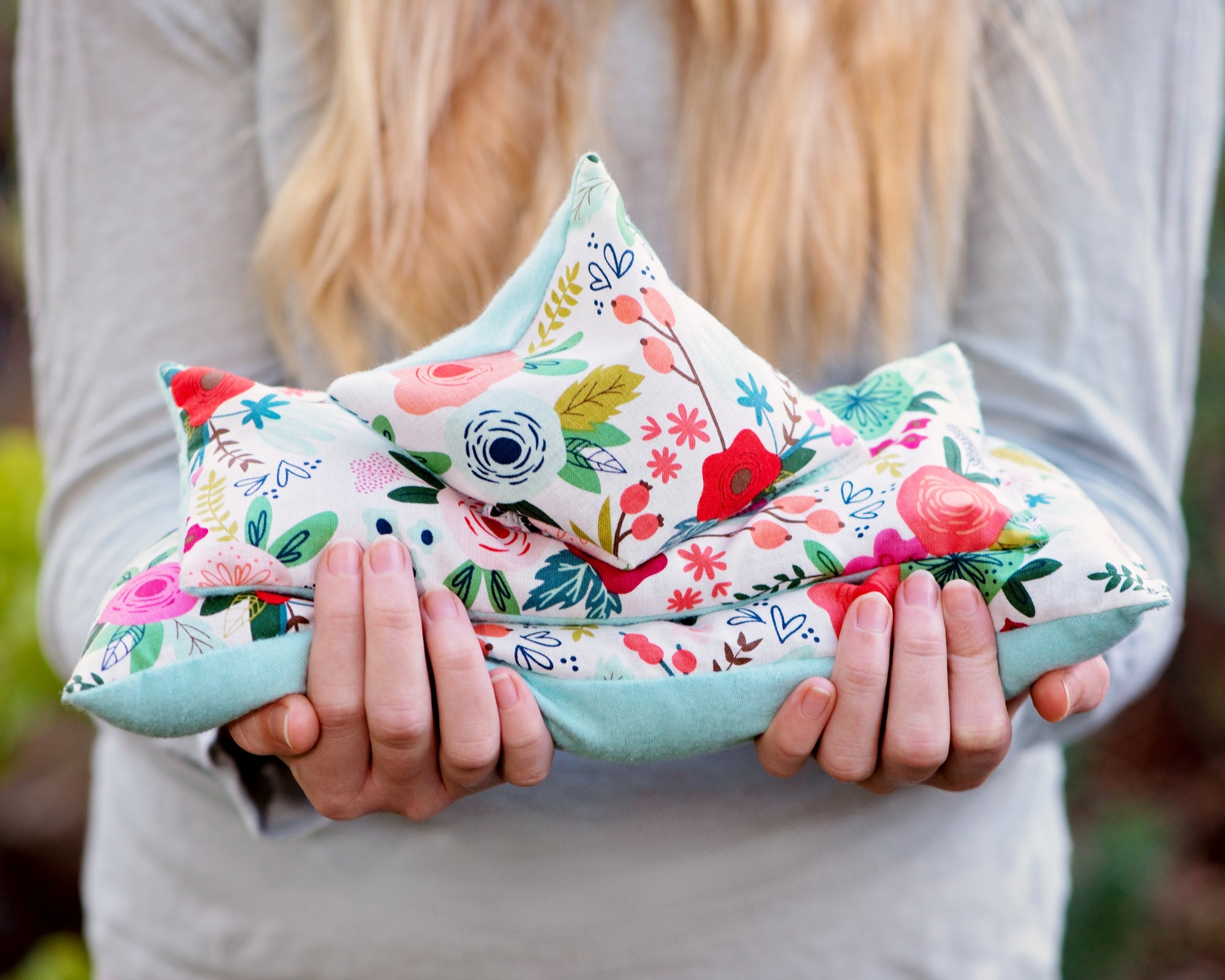Girl holding microwave heating pads and or ice packs in her hands.